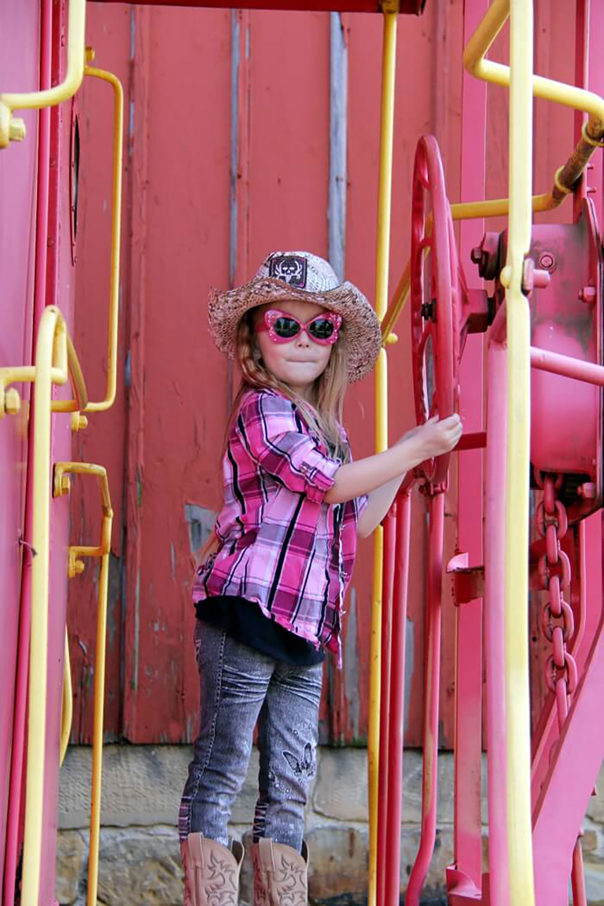 Cowgirl portrait on train step in rustic outdoor setting