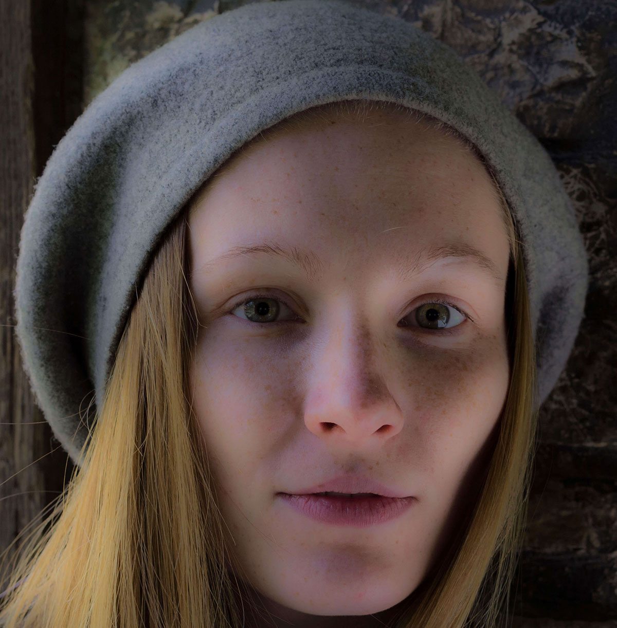 Close-up portrait of a young woman wearing a gray beret