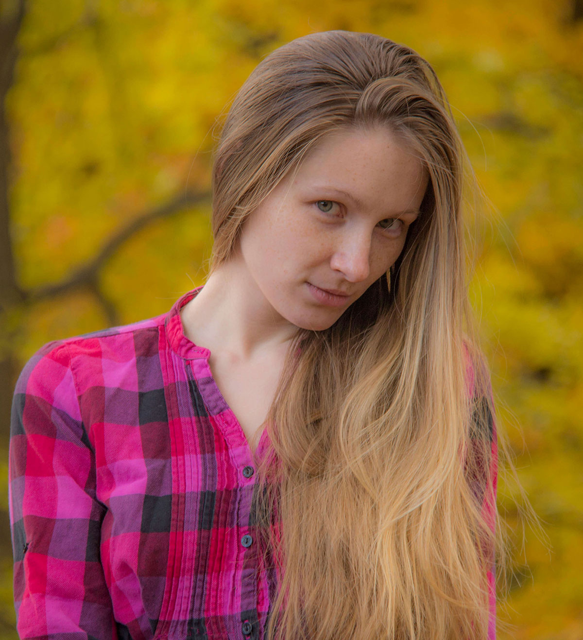 Autumn close-up portrait of a young woman in a plaid shirt